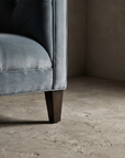 Detail of tapered wood leg and track arm base with welt seam