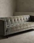 Blue-grey velvet biscuit-tufted sofa, 45 degree three-quarter view showing full length