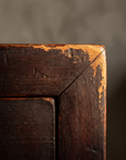 Macro detail of the top corner joinery and worn matte oxblood lacquer