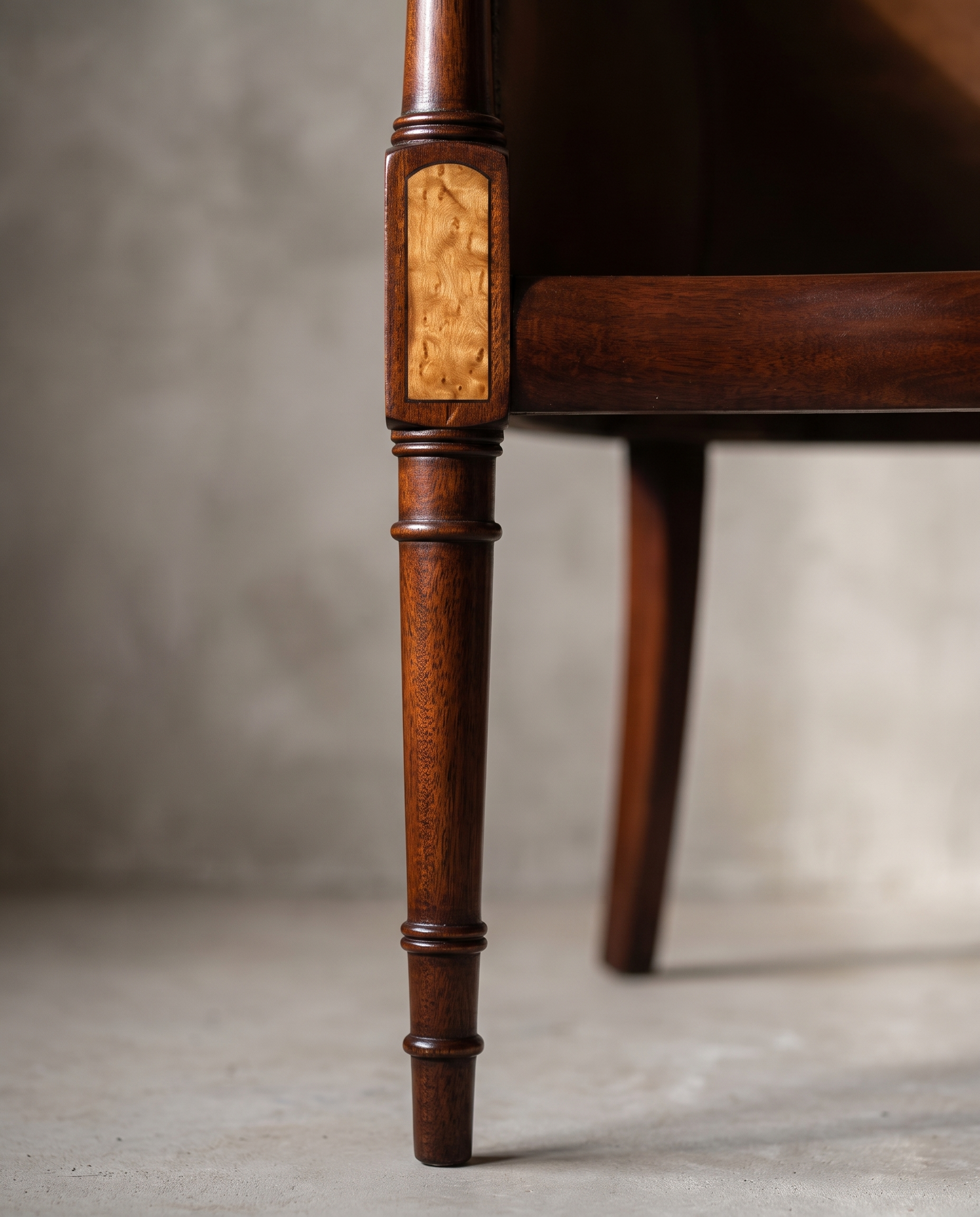 Macro detail of the reeded leg turning and burl wood inset panel, alternate angle