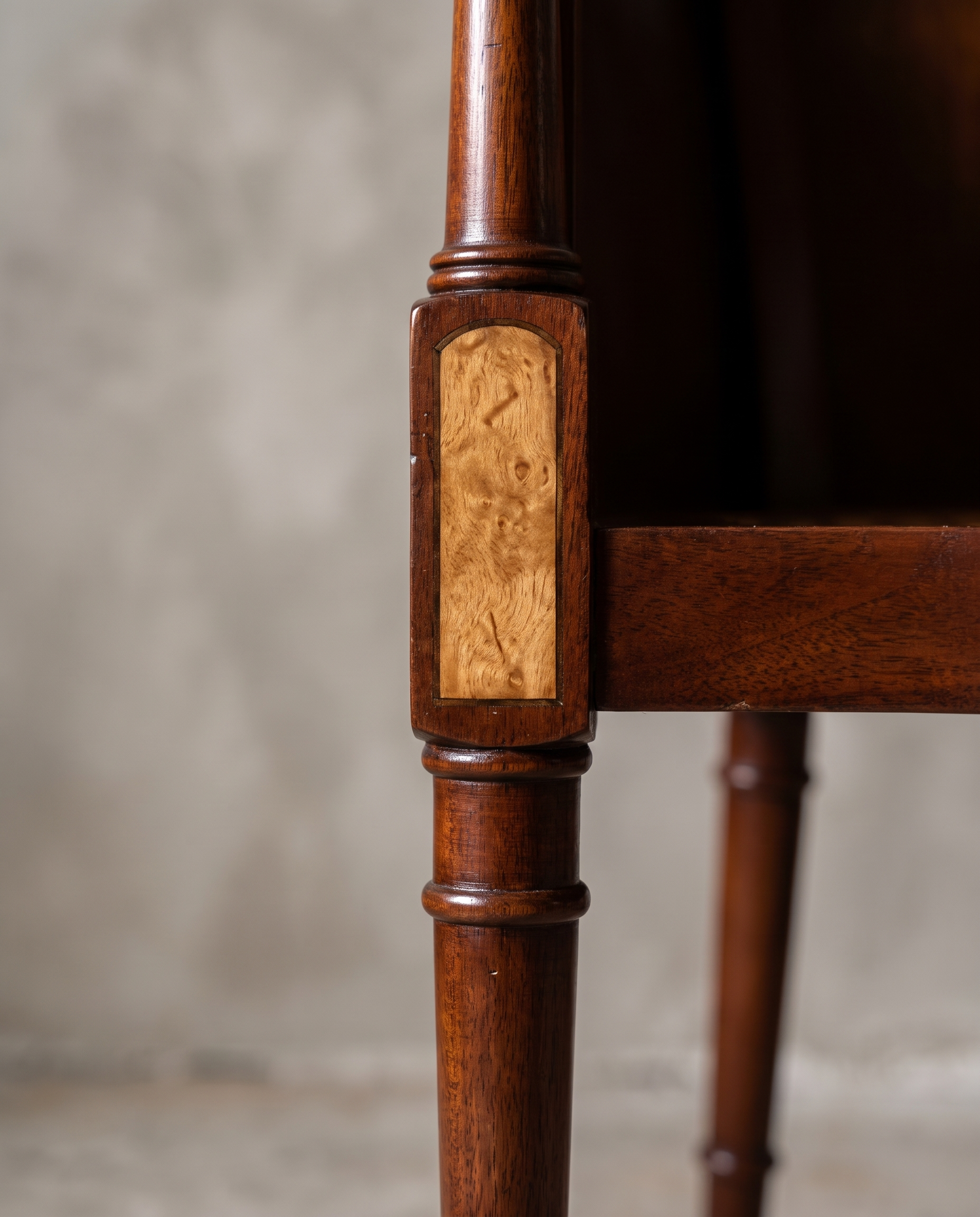 Macro detail of the reeded leg turning and burl wood inset panel