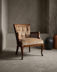 Tan velvet tufted cane-side armchair, lifestyle three-quarter view in a greige plaster room