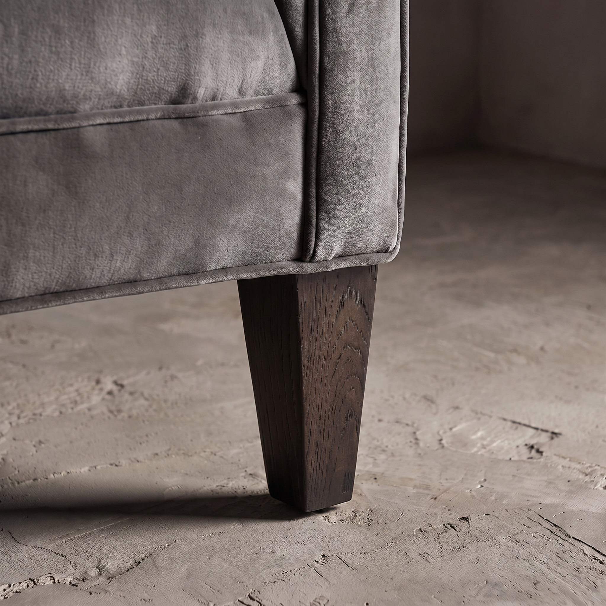 Detail of tapered wood leg and track arm base with welt seam
