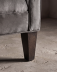 Detail of tapered wood leg and track arm base with welt seam