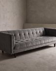 Blue-grey velvet biscuit-tufted sofa, 45 degree three-quarter view showing full length