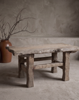 Wormwood Coffee Table, live-edge wood table against raw plaster wall