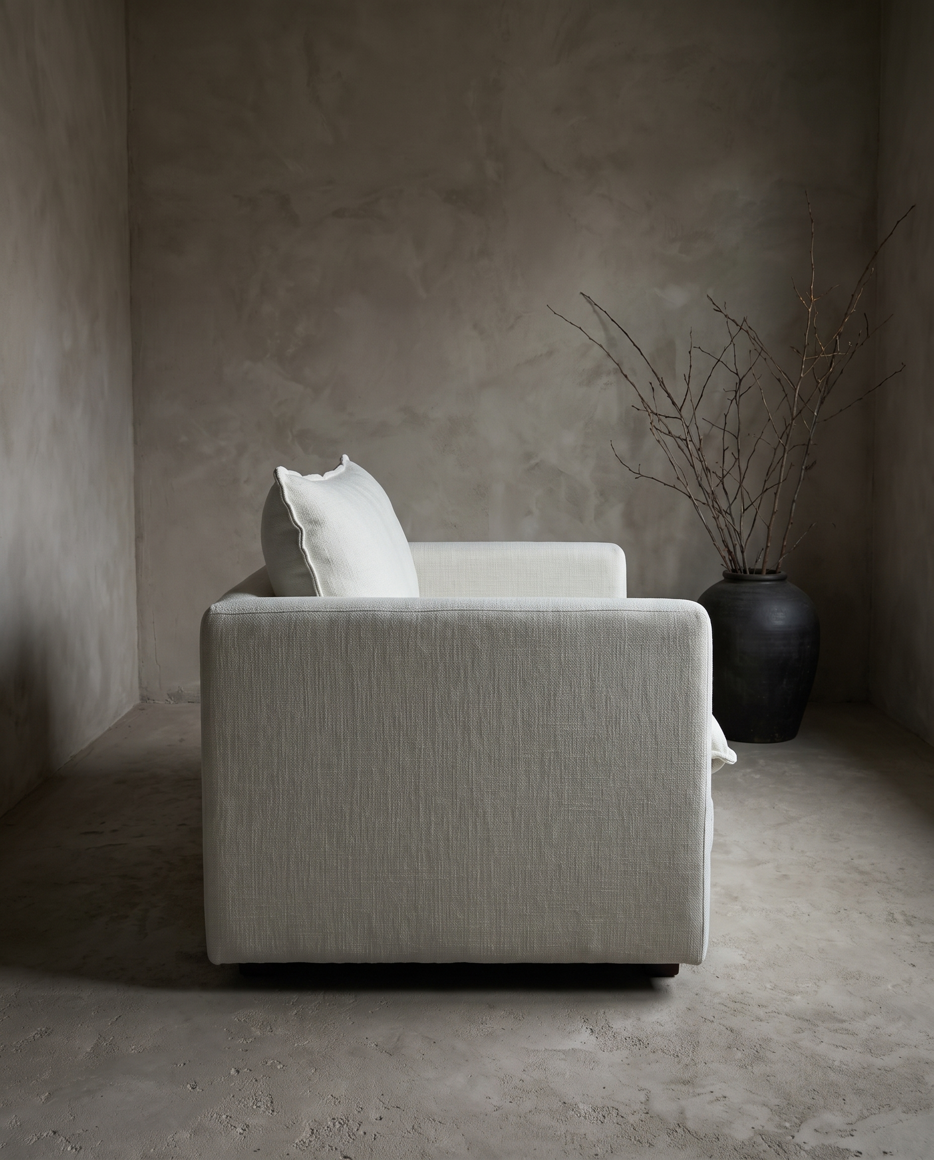 Chair and a half in white, side profile showing low arm height and plinth base