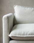 Chair and a half in white, close-up detail of arm, seat cushion, and welted seams