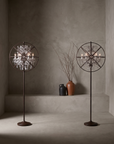 Pair of Crystal Orb floor lamps in antique rust, styled in a plaster room with stoneware vessels and dried branches