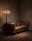 Gyro Crystal Floor Lamp by Timothy Oulton beside The Umber Chesterfield in a sultry corner with rich reclaimed redwood floors