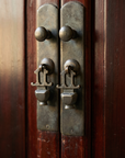 Macro detail of the ornate cast brass center-door latch hardware