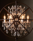 Macro close-up of the Gyro Crystal Floor Lamp's chandelier and iron rings, glowing warm and sultry in low amber light