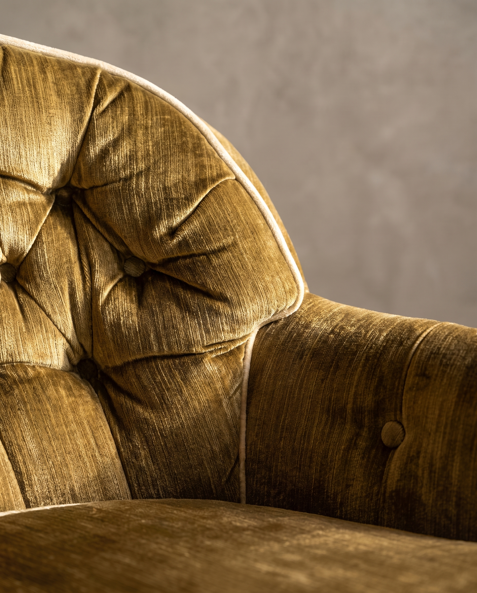 Detail of diamond button-tufted back, arm button, and cream welt piping