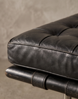 Detail of the Barcelona Daybed's diamond button-tufted black leather cushion and leather strap suspension
