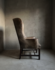 Brown leather RH wingback chair, side profile showing the wing and low arm silhouette