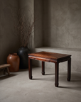 Antique Chinese key-fret side table styled in a quiet greige plaster room with stoneware vessels and dried branches