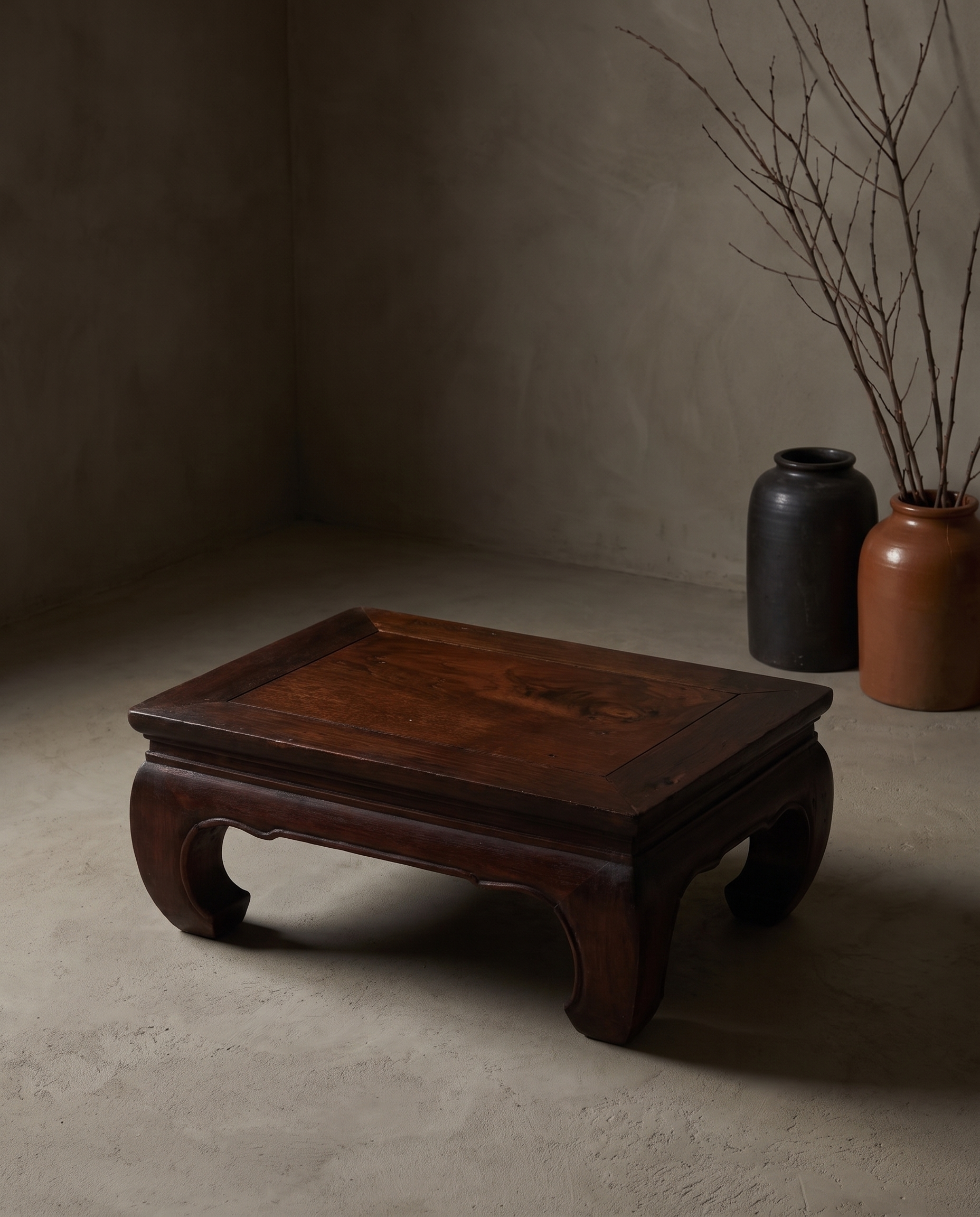Medium Kang Table, lifestyle view in a greige plaster room with stoneware vessels and dried branches