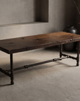 Rustic reclaimed wood coffee table with blackened iron pipe base, lifestyle view in a plaster room with stoneware vessels