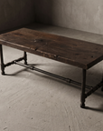 Rustic reclaimed wood coffee table, three-quarter view showing full form and iron pipe base construction