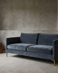 Smoked slate velvet track-arm sofa, lifestyle hero in a greige plaster room