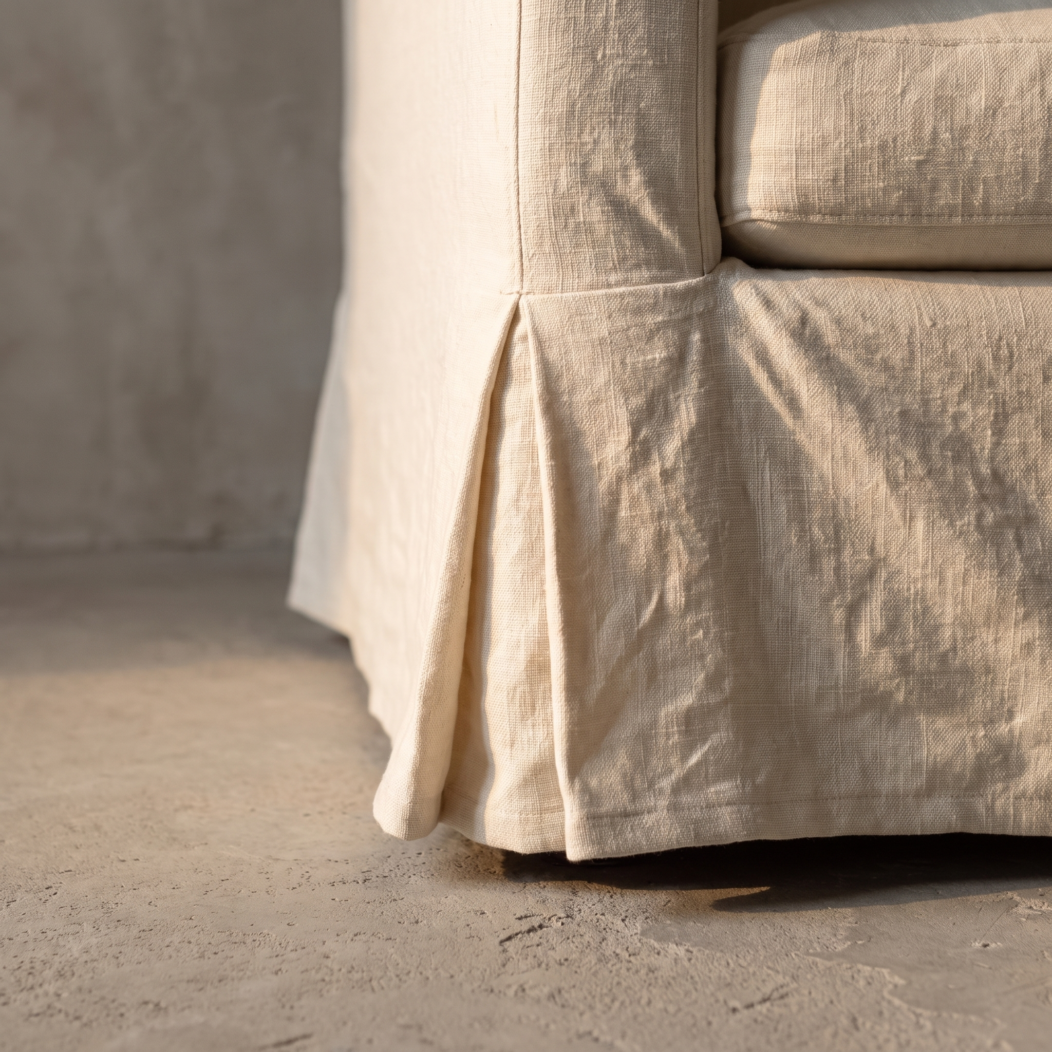 Detail of the kick-pleat linen skirt corner on the sofa