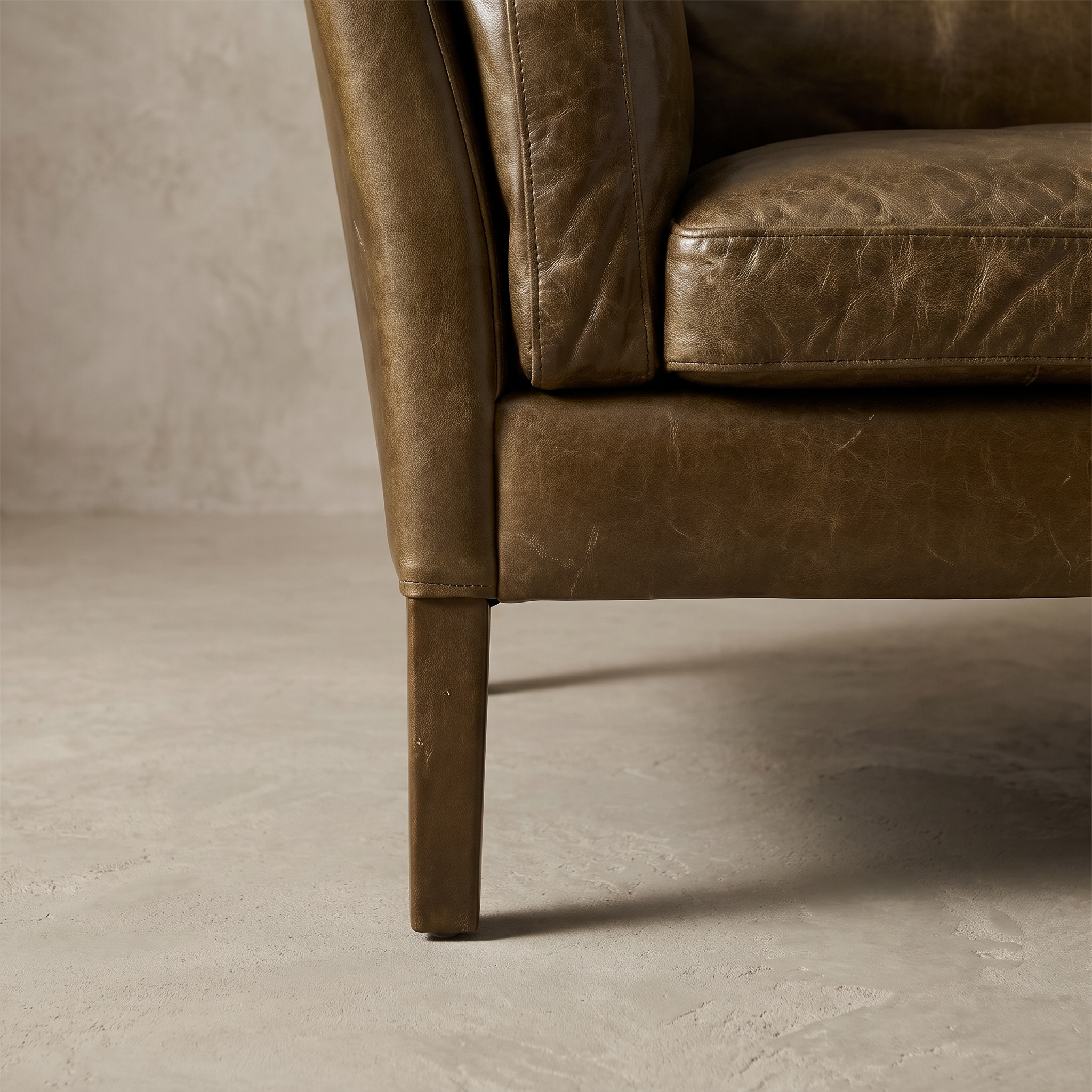 Macro detail of the leather-wrapped tapered leg, lightly worn