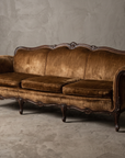 Vintage brown velvet Victorian camelback sofa, three-quarter view showing carved frame and cabriole legs