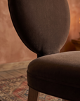 Detail of the oval velvet back and seat junction, warm domestic room