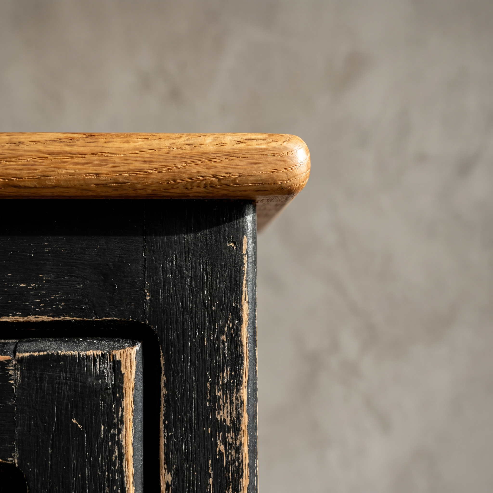 Detail of the Little Pantry Armoire's natural oak top edge meeting the black painted case