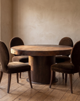 All four chairs pulled up around a round reclaimed cast-iron boiler table