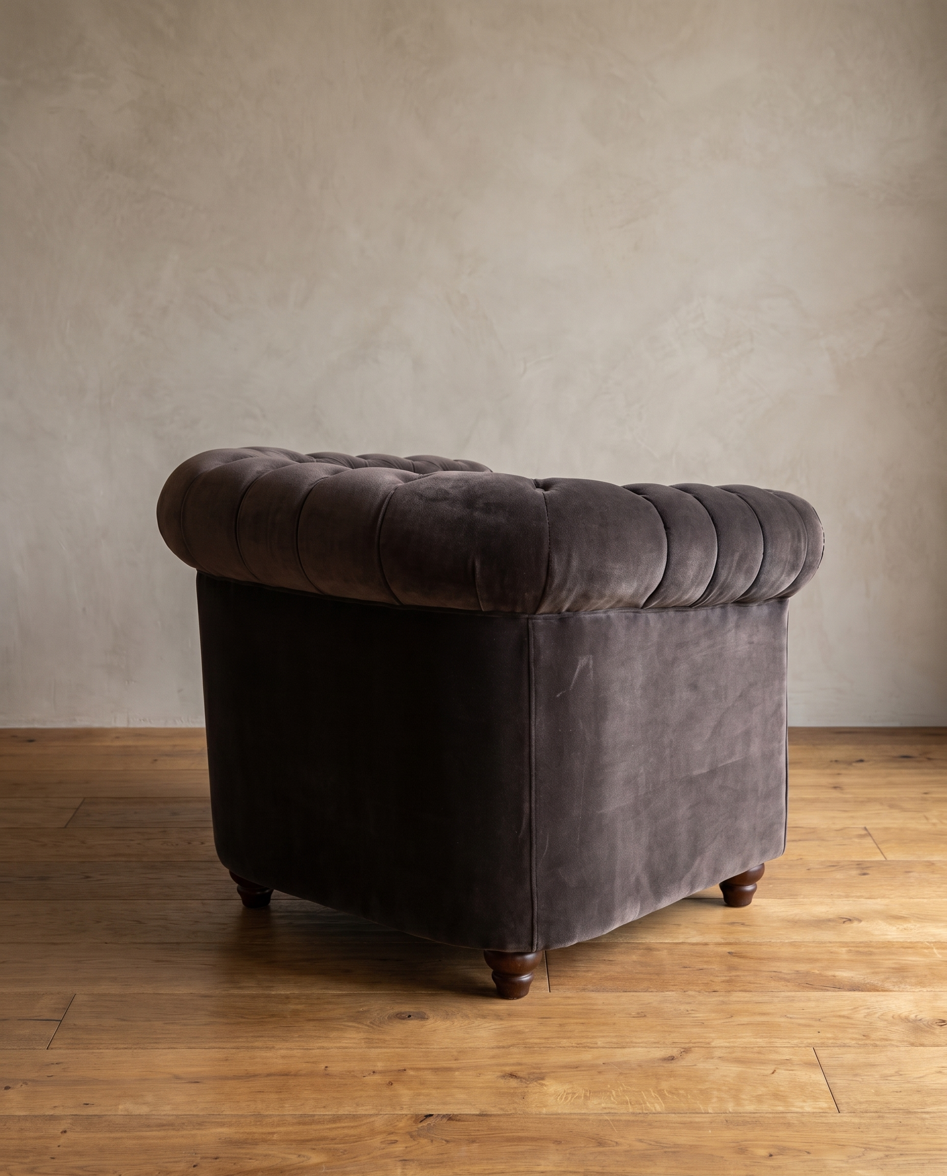 Smoke grey velvet barrel chair, three-quarter back view showing rolled arm and turned bun feet