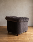Smoke grey velvet barrel chair, three-quarter back view showing rolled arm and turned bun feet