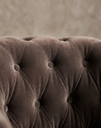 Macro detail of diamond button tufting on smoke grey velvet
