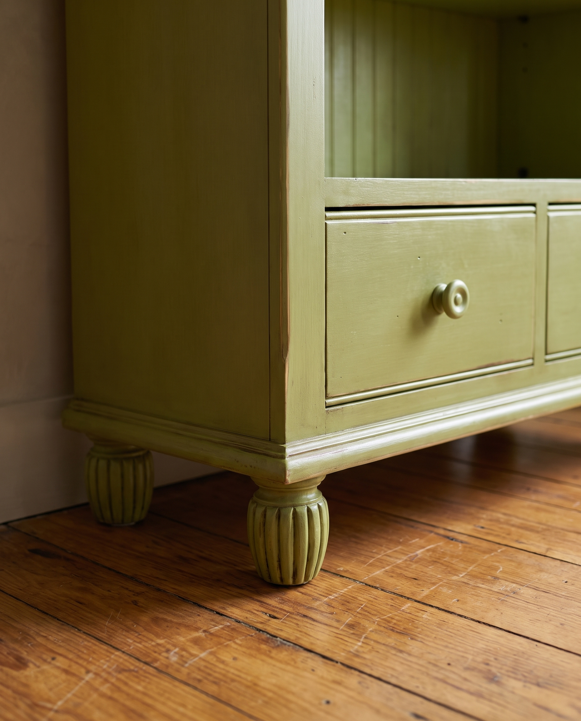 Detail of the bookcase base with drawers and reeded bun feet