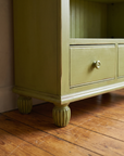 Detail of the bookcase base with drawers and reeded bun feet