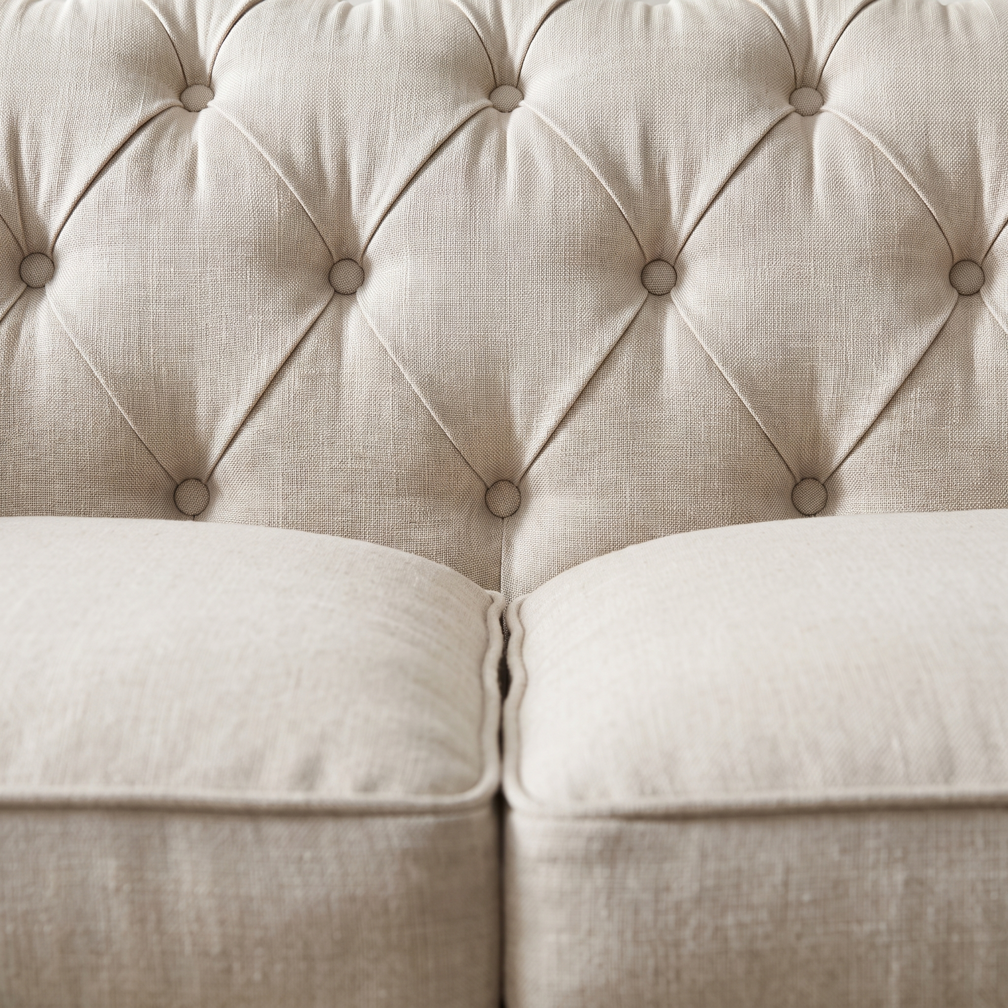 Macro of the deep diamond button tufting where the back meets the seat cushions