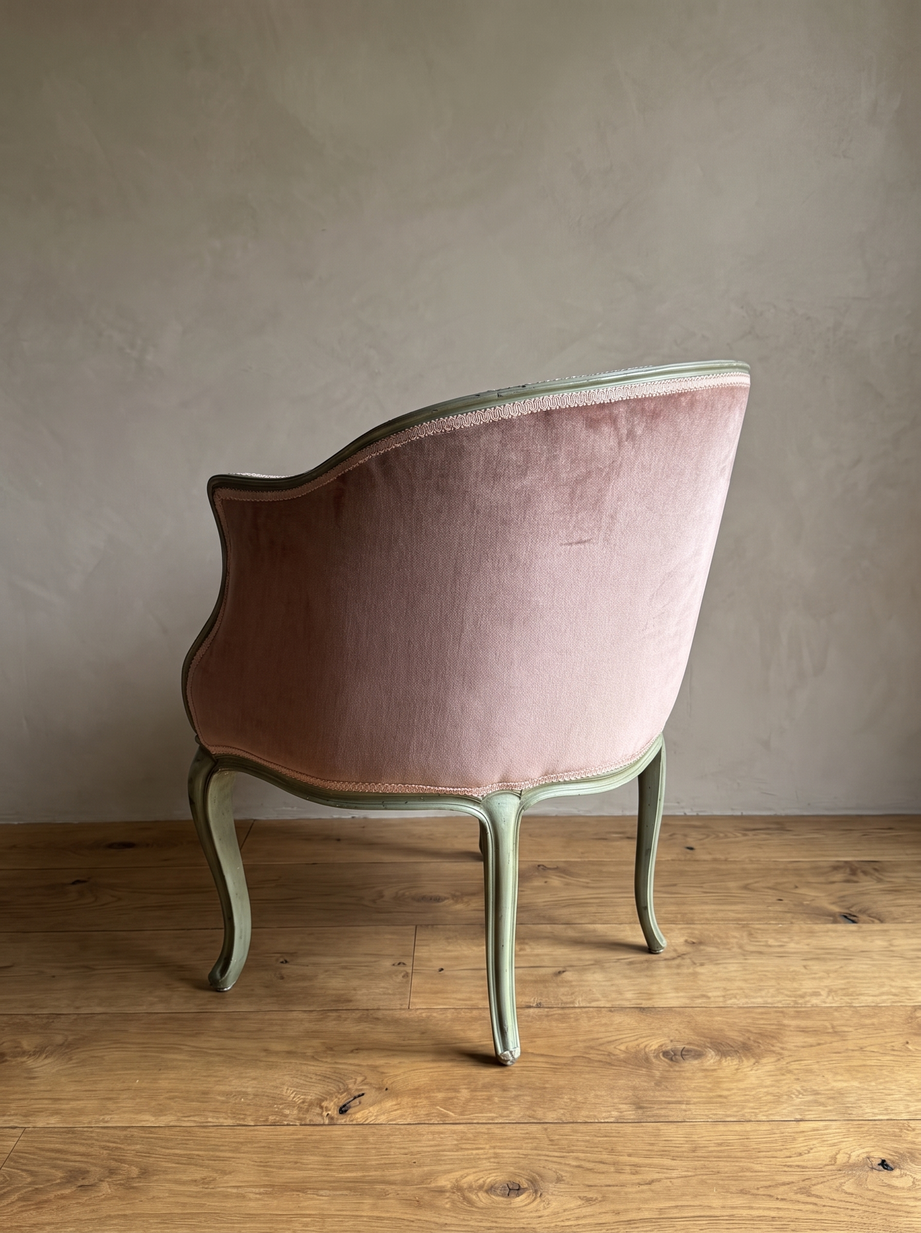 Back view of the rose velvet bergère showing the rounded tub back