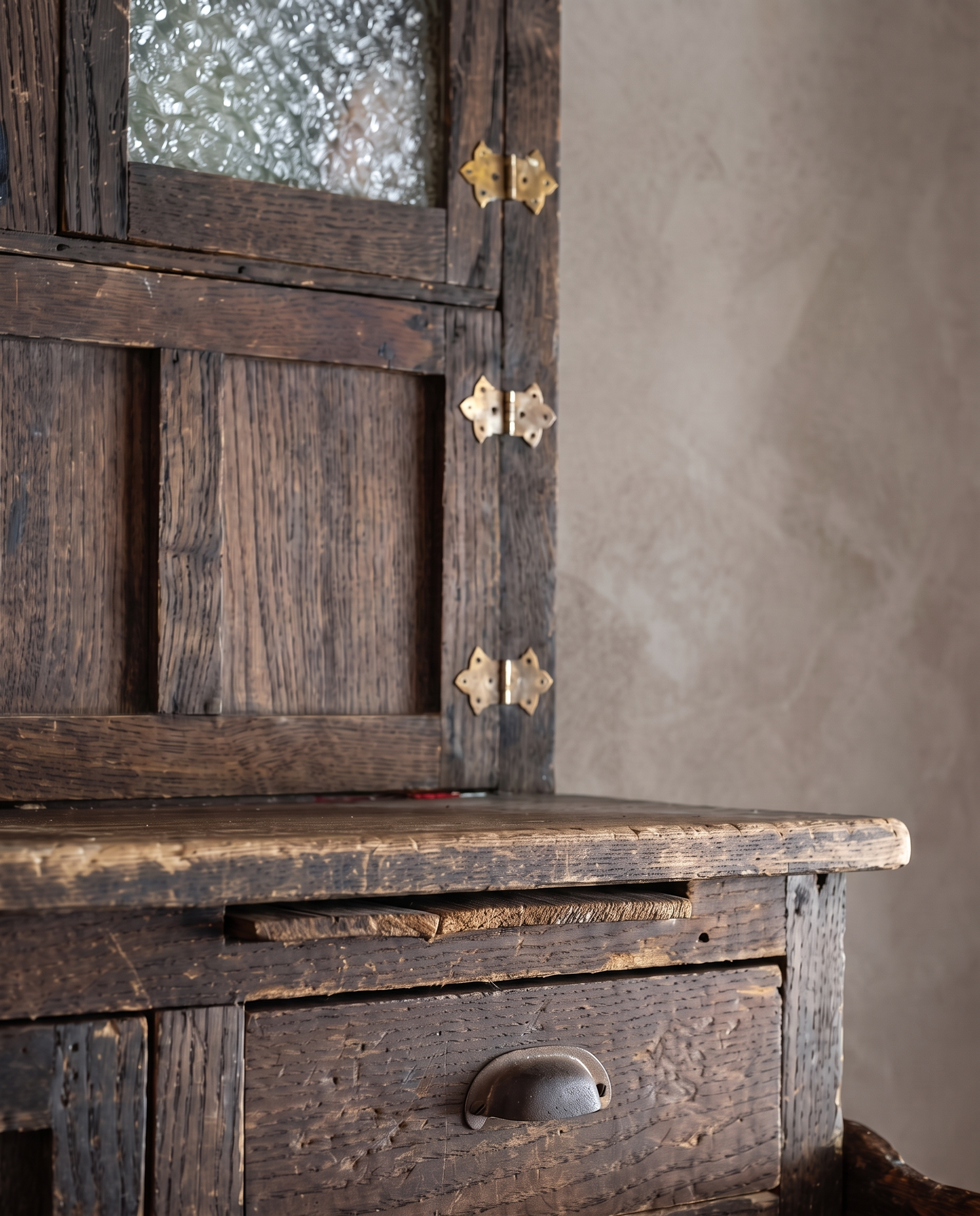 Detail of textured glass door, brass hinges and worn countertop on the Antique Hoosier Bakers Cabinet