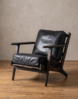 Three-quarter view of the Ember lounge chair in black leather and black wire-brushed oak