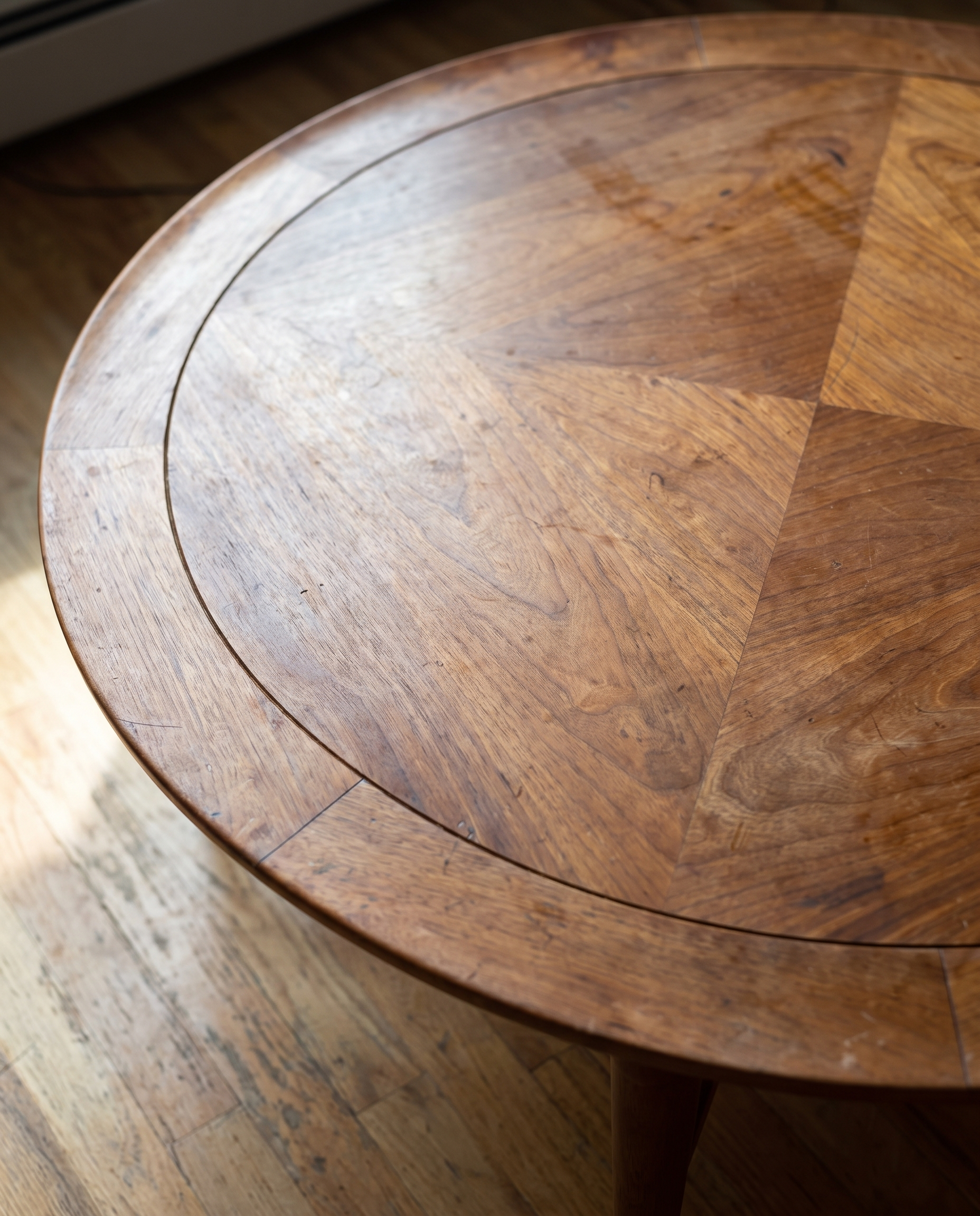 Close detail of the book-matched walnut veneer top, inset banding, and rounded rim