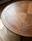 Close detail of the book-matched walnut veneer top, inset banding, and rounded rim
