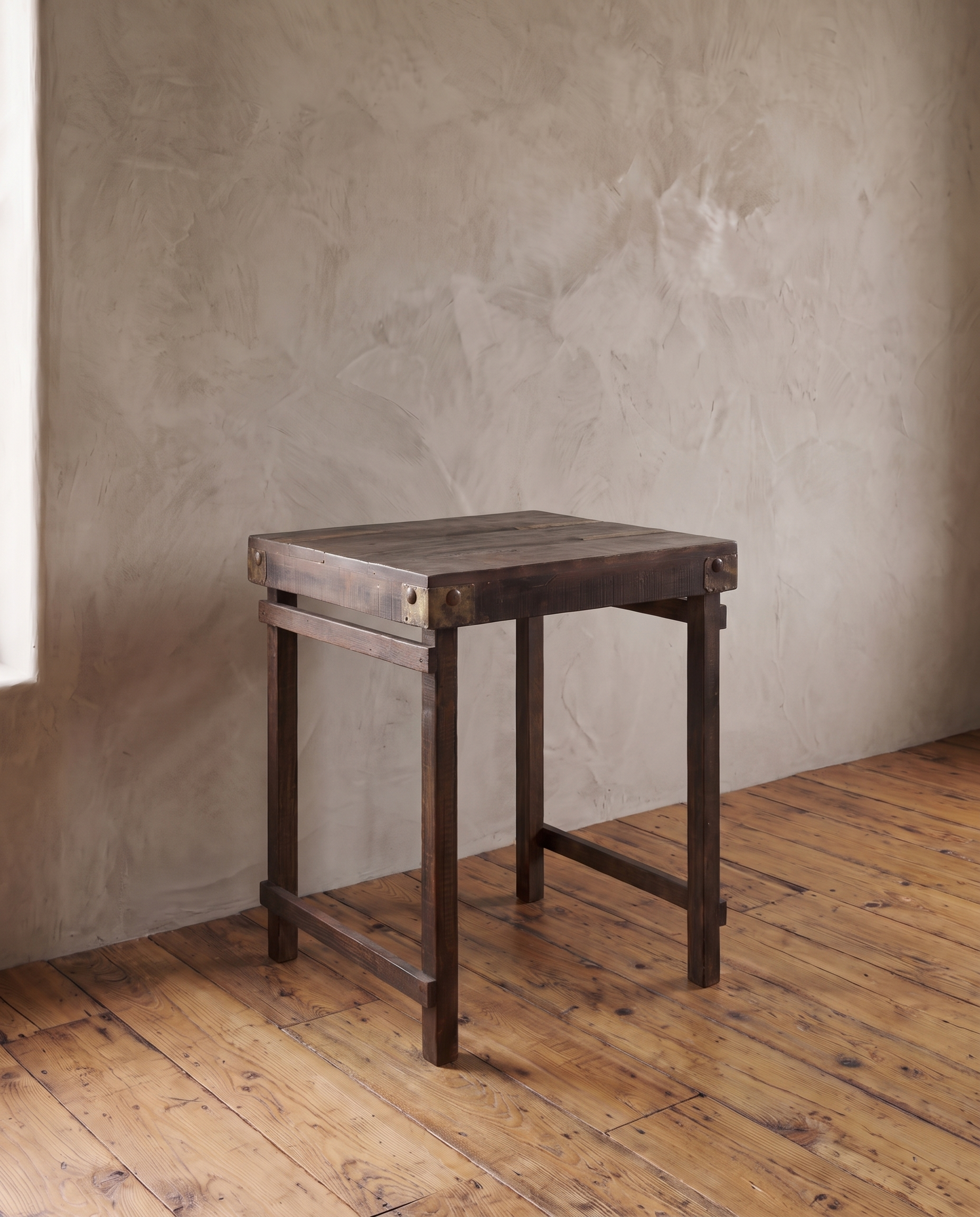 Three-quarter view of the vintage Indian side table alone, showing the plank top, metal corner plates and leg stretchers