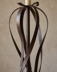 Close-up of hand-hammered steel ribbons curving around the central stem