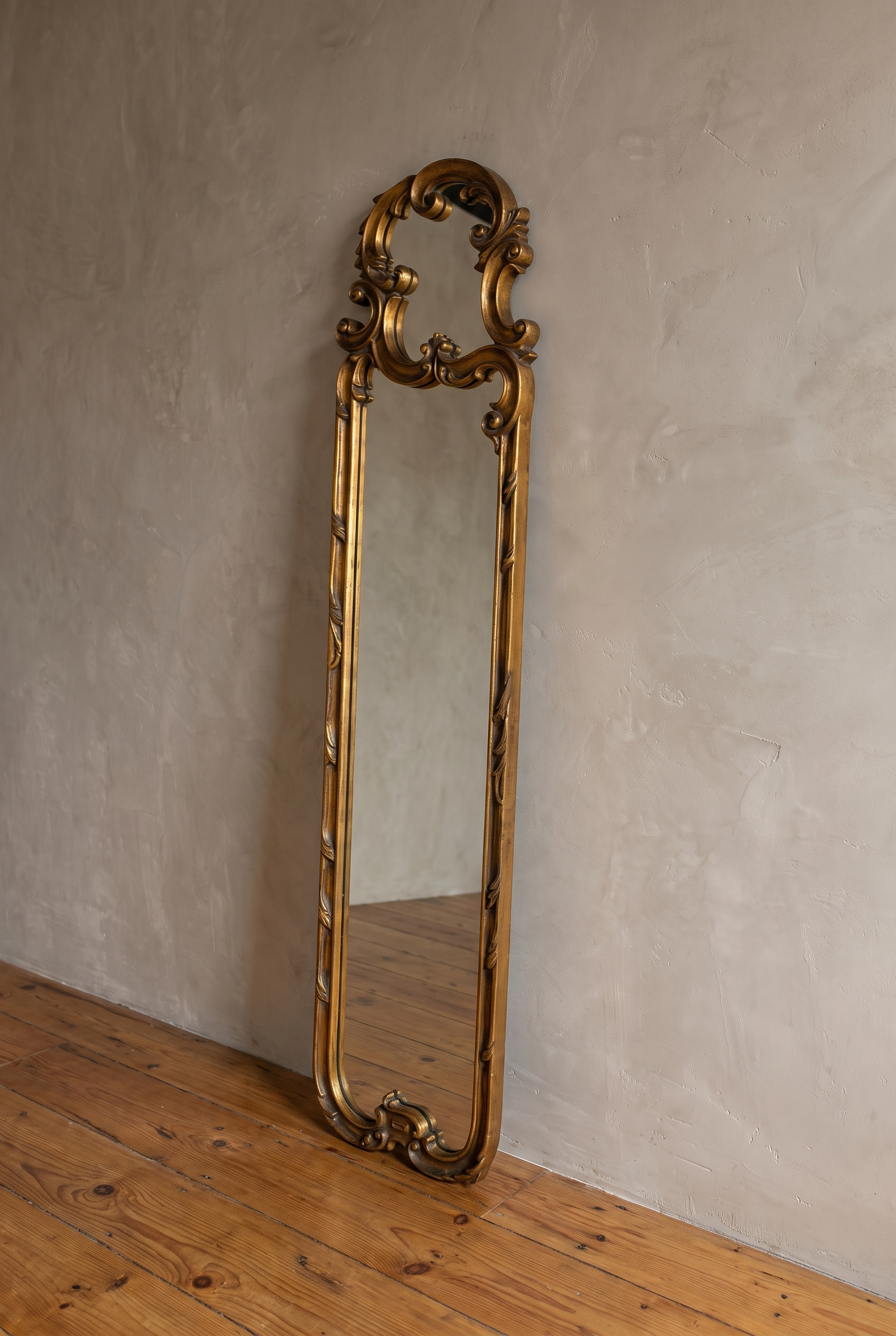 Three-quarter view of the carved gilt scroll mirror frame