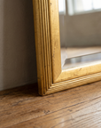 Close-up of the lower frame corner resting on the wood floor