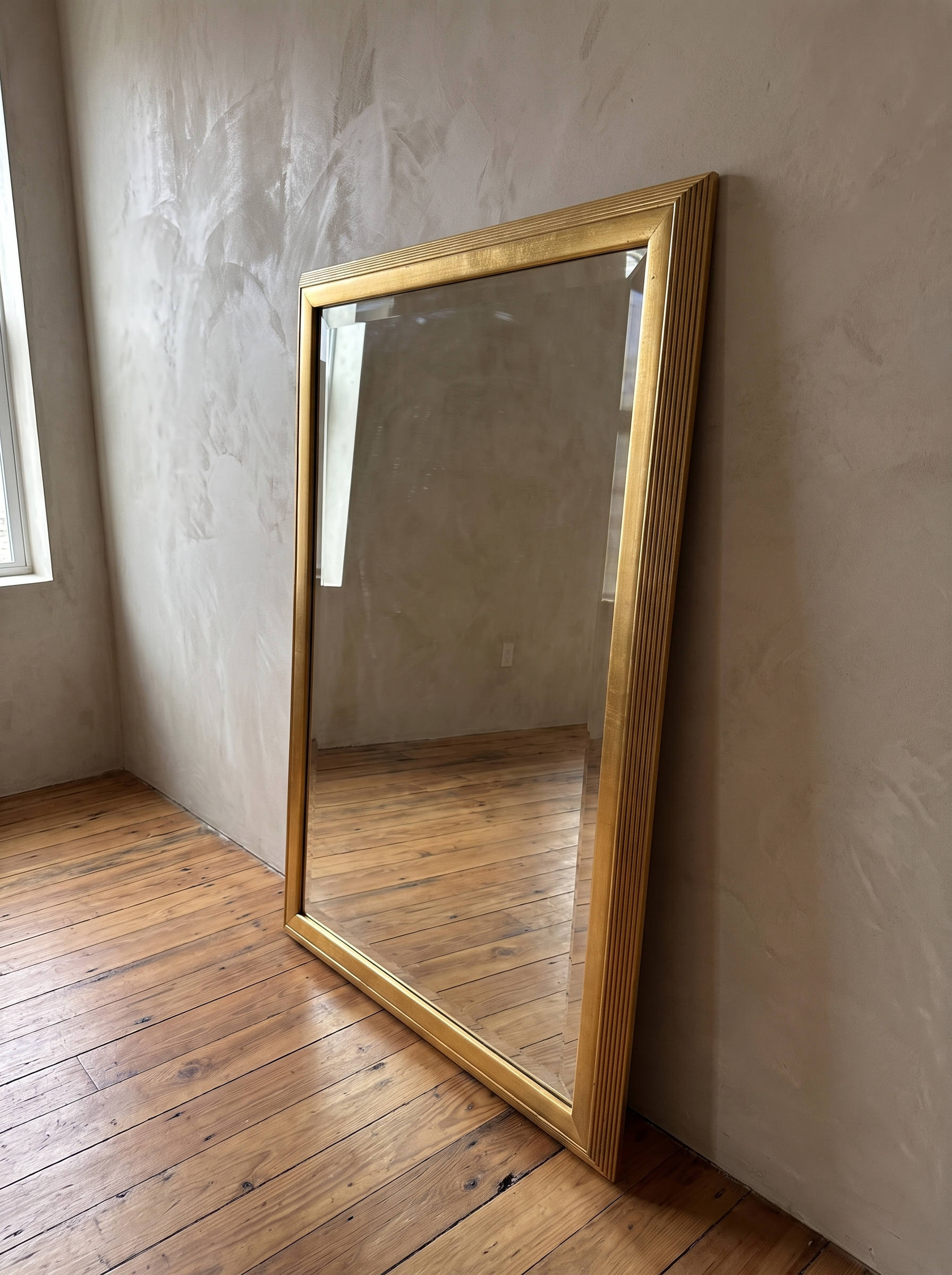 Three-quarter view of the gilt reeded mirror showing the frame depth