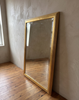 Three-quarter view of the gilt reeded mirror showing the frame depth