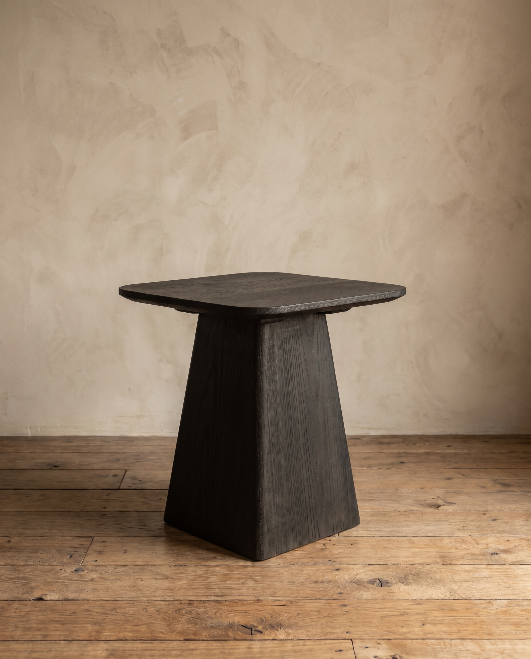 Ember Side Table in charred black Shou Sugi Ban wood against a plaster wall on a reclaimed wood floor
