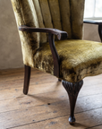 Detail of the carved ribbed scroll arm and crushed velvet seat
