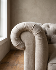 Close detail of the rolled scroll arm with soft gathered folds in slubby natural flax linen
